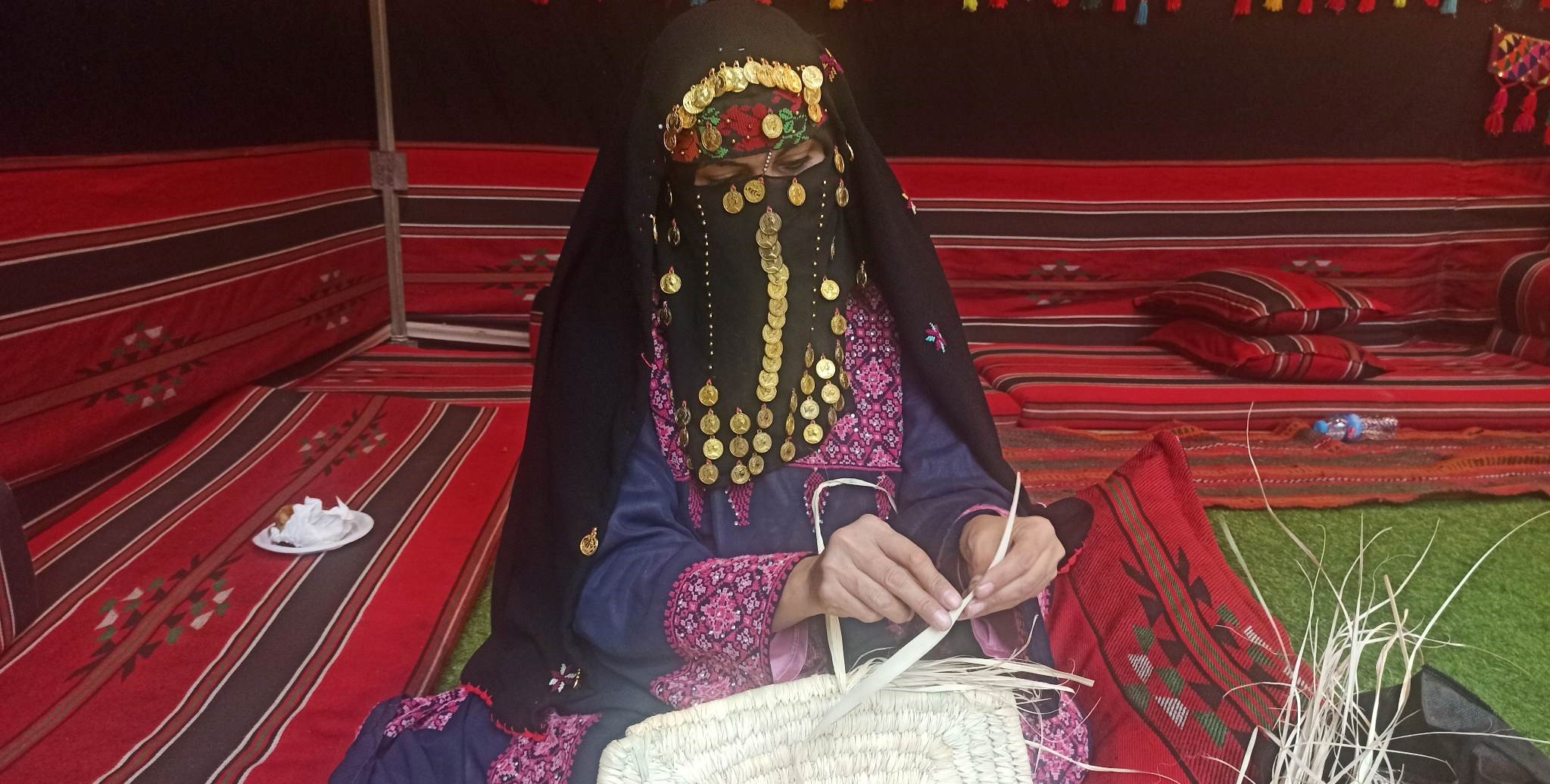 الفلسطينية افتخار يوسف تعيد صناعة السلال الملونة من سعف النخيل
